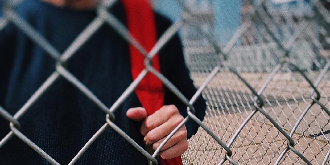 teen behind fence