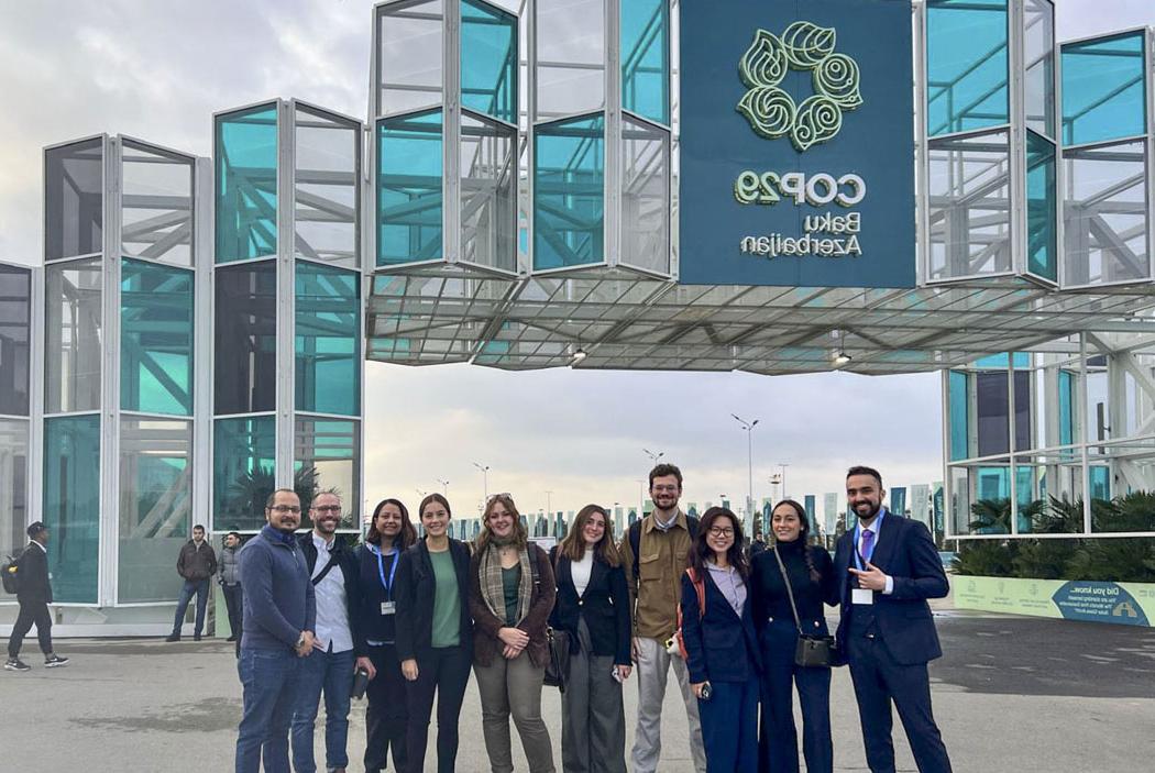 delegates in front of a COP29 sign